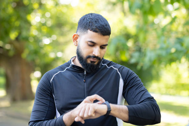 istock Active man checking fitness tracker in a park 2106764617