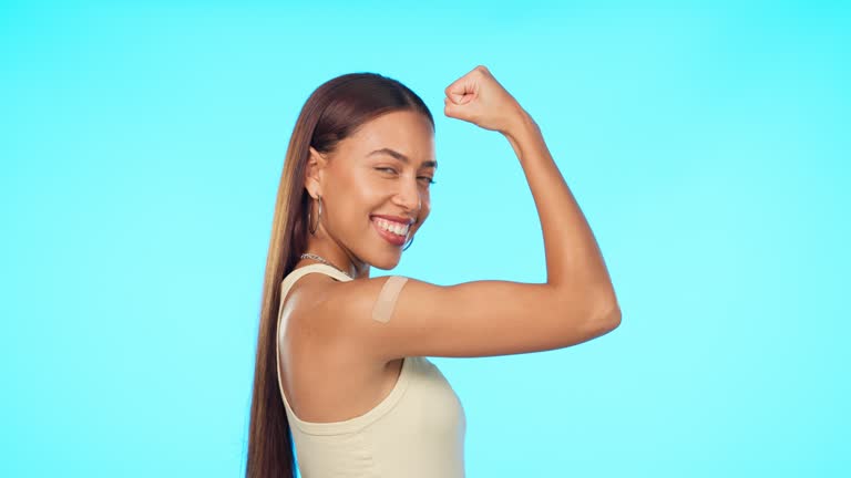 Face, smile and woman flex muscle in studio isolated on a blue background mockup. Portrait, strong bicep and female person with power, empowerment or challenge, fitness and exercise with bandage.