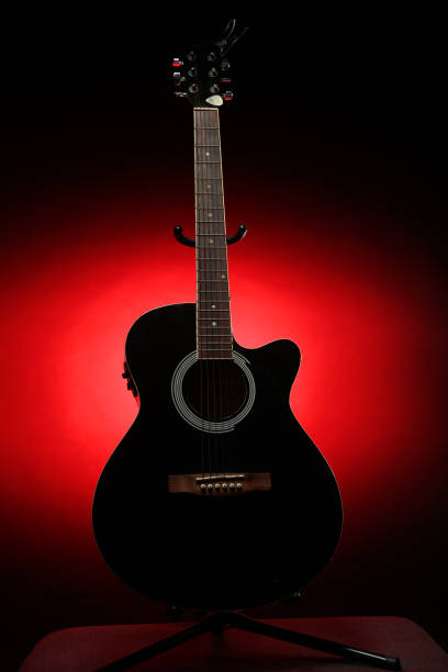 istock Black acoustic guitar photographed with color lighting 2106824805