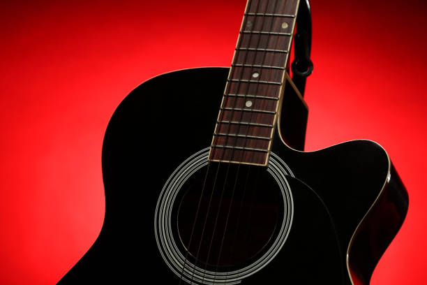 istock Black acoustic guitar photographed with color lighting 2106825318