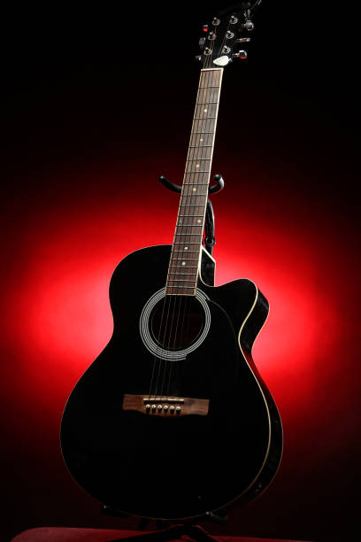 istock Black acoustic guitar photographed with color lighting 2106825322