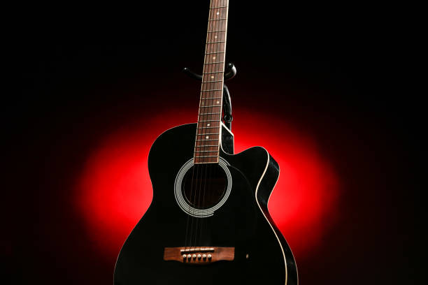 istock Black acoustic guitar photographed with color lighting 2106825328