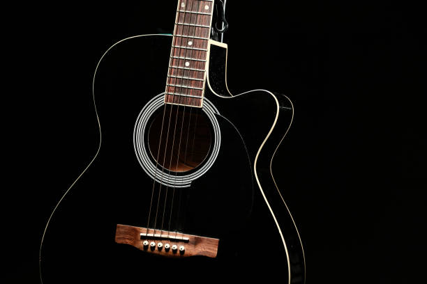 istock Black acoustic guitar photographed with color lighting 2106825342