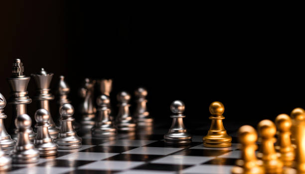 istock Chess standoff. Silver versus gold on chessboard. 2106838675