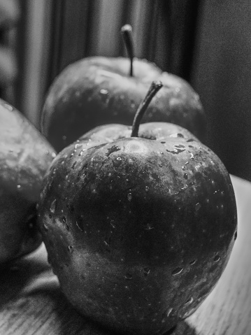 Big apple. Close-up shot. Wet fruits. Black and white image.