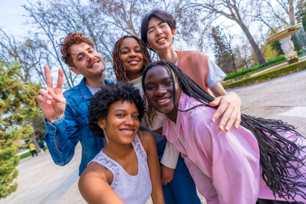 istock Cute young multiracial friends talking selfie in a park 2106852911