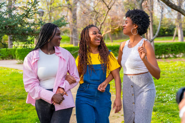 istock Friends walking and chatting along a park 2106867820