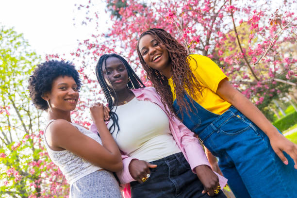 istock African young woman posing next to cherry tree 2106867998