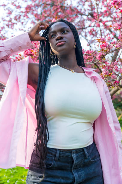 istock African model posing next to flowering pink tree 2106868116