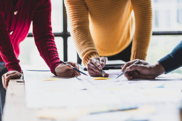 istock UX, UI designers collaborate to design user interfaces for smartphone apps based on user experience. Colleagues meeting, program designers brainstorm to discuss designing mobile applications. 2106881515