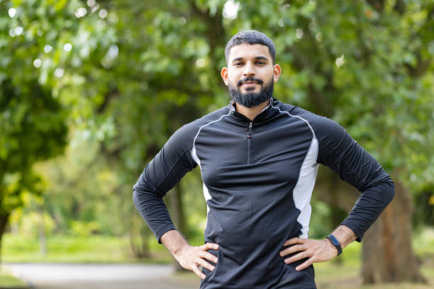 istock Confident man standing with hands on hips in a park 2106893140