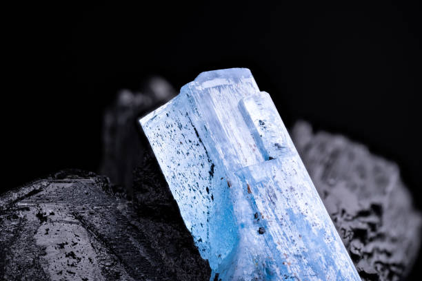 Aquamarine (blue beryl) on schorl (black tourmaline) macro photography detail texture background. From Namibia. close-up raw rough unpolished semi-precious gemstone