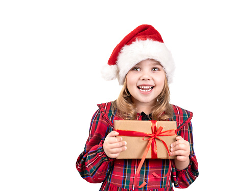 Little girl holding present box isolated on white. Child in christmas hat,costume with gift in hands.Caucasian kid new year concept.