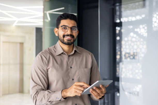 istock Confident professional male entrepreneur with tablet in modern office space. 2106925648