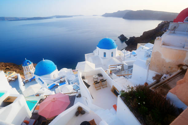 traditional greek village Oia of Santorini, with blue domes of churches and village street, Greece