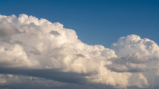 There is a large, cumulus cloud in the blue sky. Close-up