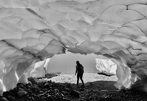 Young man explores ice-caves, Whistler, BC