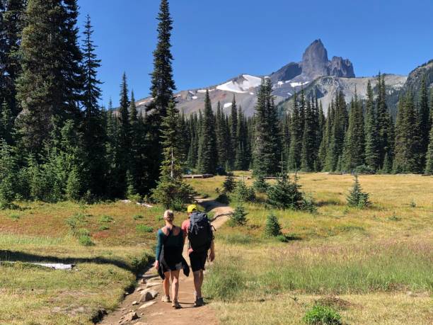 istock Couple hike towards mountain peak 2106980143