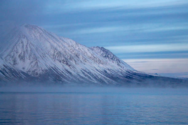 Early morning light on mountains and lake with mist rising