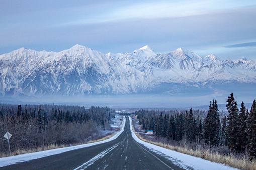 View down highway to mountains in winter