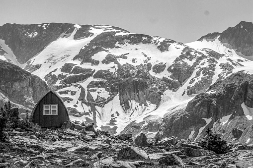 Mountain hut on pass with snowcapped mountains behind