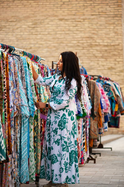 istock Khiva, a lady looking at merchandise in a market 2106988010