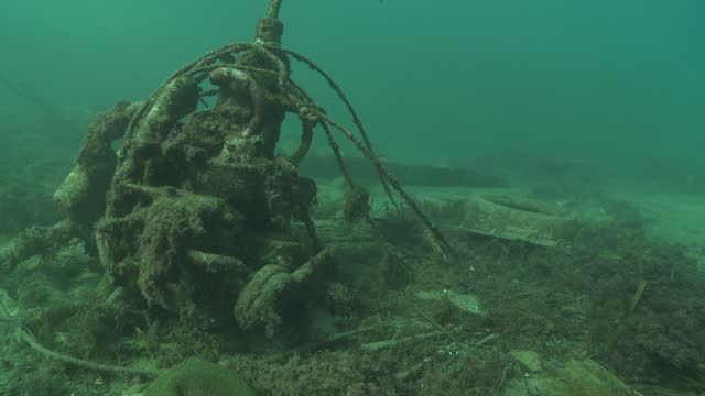 A boat engine reaches the end of its life resting on the ocean floor.
