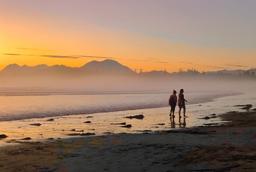 Young couple explore wild beach at sunset, Pacific Northwest