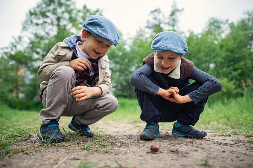 Two kids aged 6 examining a roman snail on the path.\nShot with Nikon D800