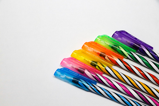colorful pens on white background.