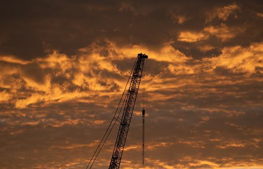 Industrial crane rises into the evening sky