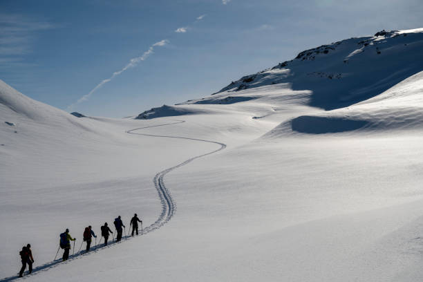 istock Ski mountaineers ascend snowcapped mountain 2107081153