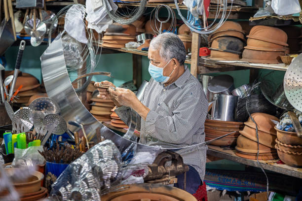 Sabang, Pulau Weh, Indonesia - January 13th 2024: Man with a protective facemask in his hard ware stall in the marked hall in the city of Sabang which in the main city on the island Weh north of Sumatra