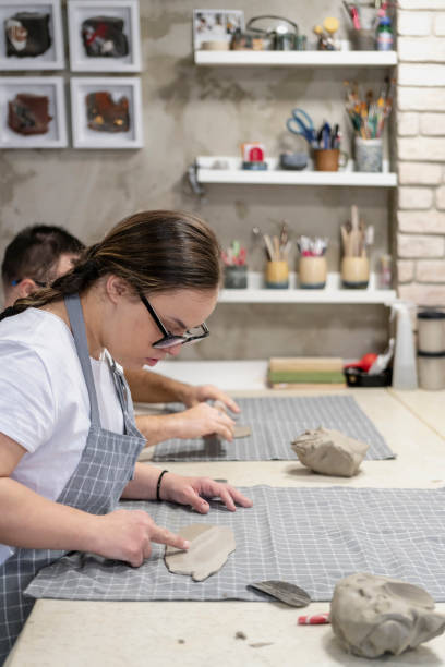 istock Young people with Down Syndrome at ceramics workshop 2107106761
