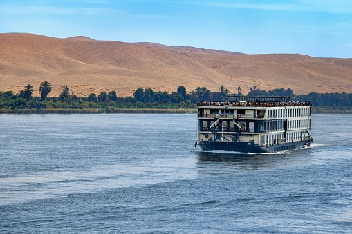 Kom Ombo, Egypt, April 14, 2023: A cruise ship sails down the Nile River in Upper Egypt on a spring morning.