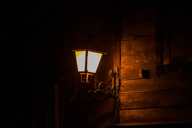 Retro style lantern at night. Beautiful colorful illuminated lamp at the balcony in the garden. Selective focus