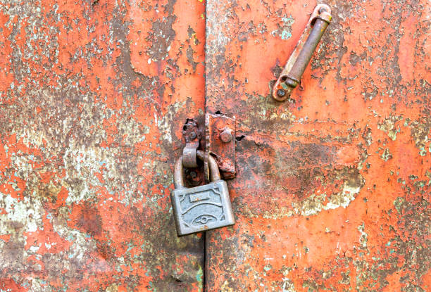 A rusty door with a lock on it. The lock is silver and the door is brown