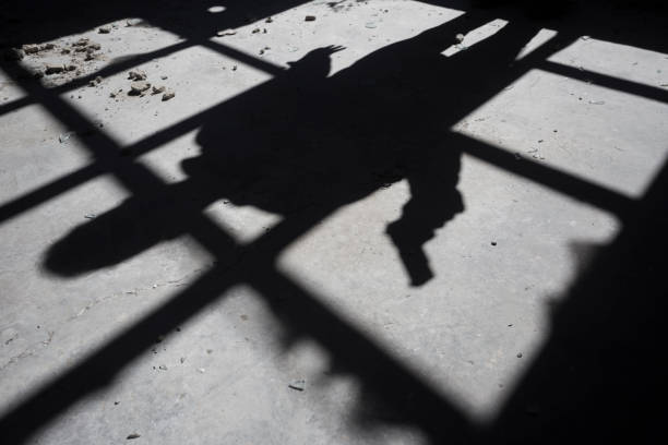 istock Shadow of a man with gun 2107212196