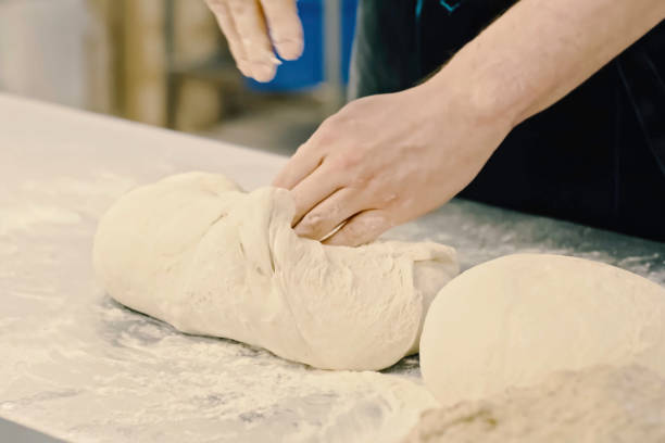 istock Rolling out dough with your hands, flour and white dough. 2107248255
