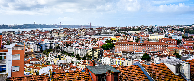 Lisbon, Portugal 23 Oct, 2022 - Overview of Lisbon Baixa district skyline and Praça Martim Moniz, with the 25 de Abril Bridge and Cristo Rei in the background. View from the Senhora do Monte viewpoint, in the city of Lisbon, Portugal.
