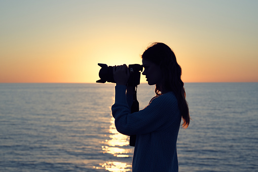 woman photographer with professional camera landscape sunset fresh air. High quality photo