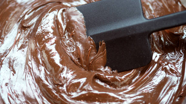 close-up images of chocolate bar top view angle and cocoa seed with bowl of dark brown cream milk swirling by handmade for represent one of delicious sweet in the world - brown chocolate candy bar close up photos et images de collection