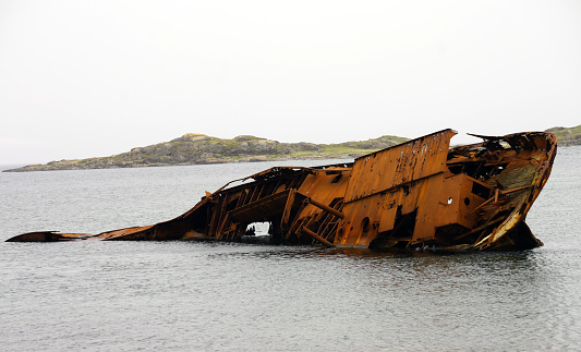 Partially submerged shipwreck near a rocky shore on the Labrador coast