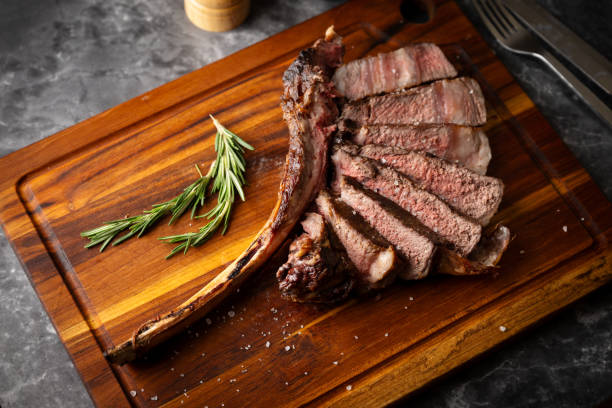 istock sliced tomahawk steak on wooden board 2107365261