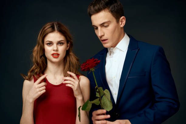 istock young couple hugs charm red rose relationship black background 2107372048