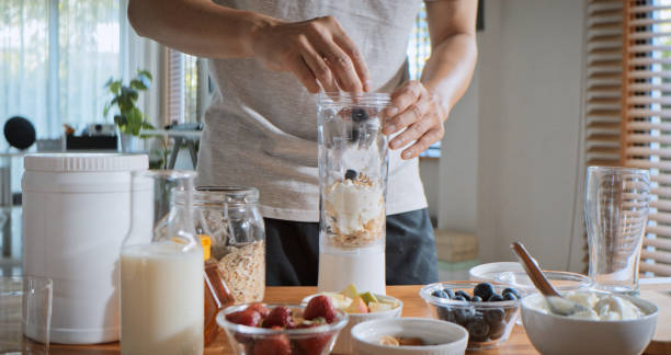istock Young adult Asian man prepare and make protein shake drink, mixed fruit cereal juice, using blender mixer. Fitness dietary activity, healthy diet lifestyle, health care nutrition concept 2107379908