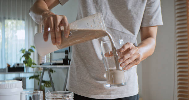 istock Young adult Asian man prepare and make protein shake drink, mixed fruit cereal juice, using blender mixer. Fitness dietary activity, healthy diet lifestyle, health care nutrition concept 2107379910