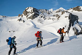 Ski mountaineers ascend snowcapped mountain, Greenland