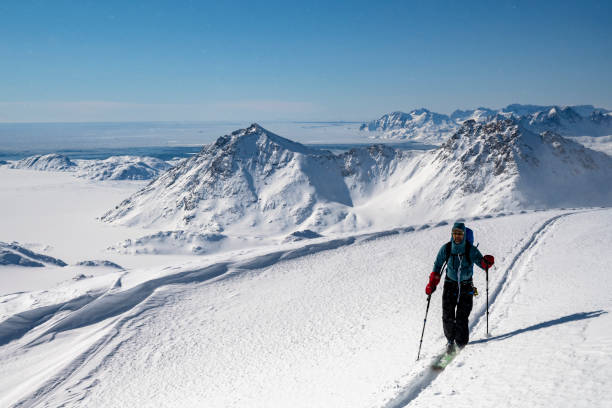 istock Ski mountaineer ascends snowcapped mountain 2107411264