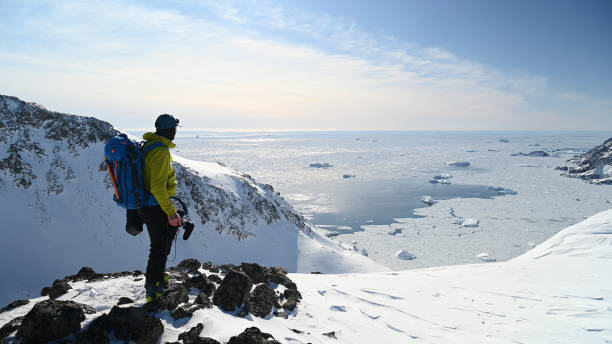 Adventure photographer prepares to shoot on mountain Adventure photographer prepares to shoot ski mountaineers on mountain slope top of ski mountain stock pictures, royalty-free photos & images